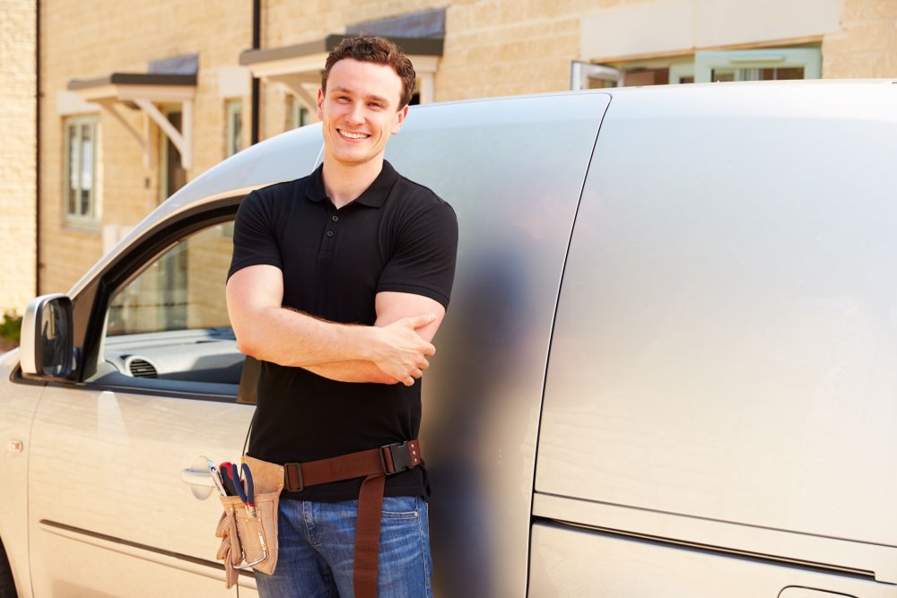 Handwerker lehnt an Transporter